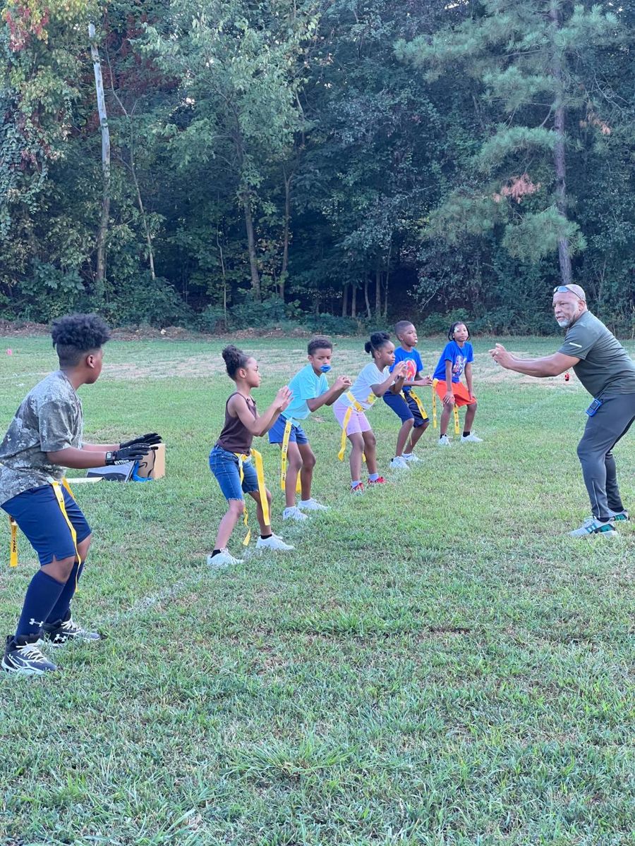 Coach leading players through a stance drill at practice