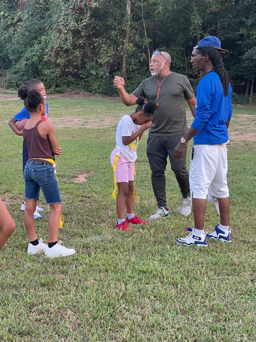Coaches talking with young players on the field